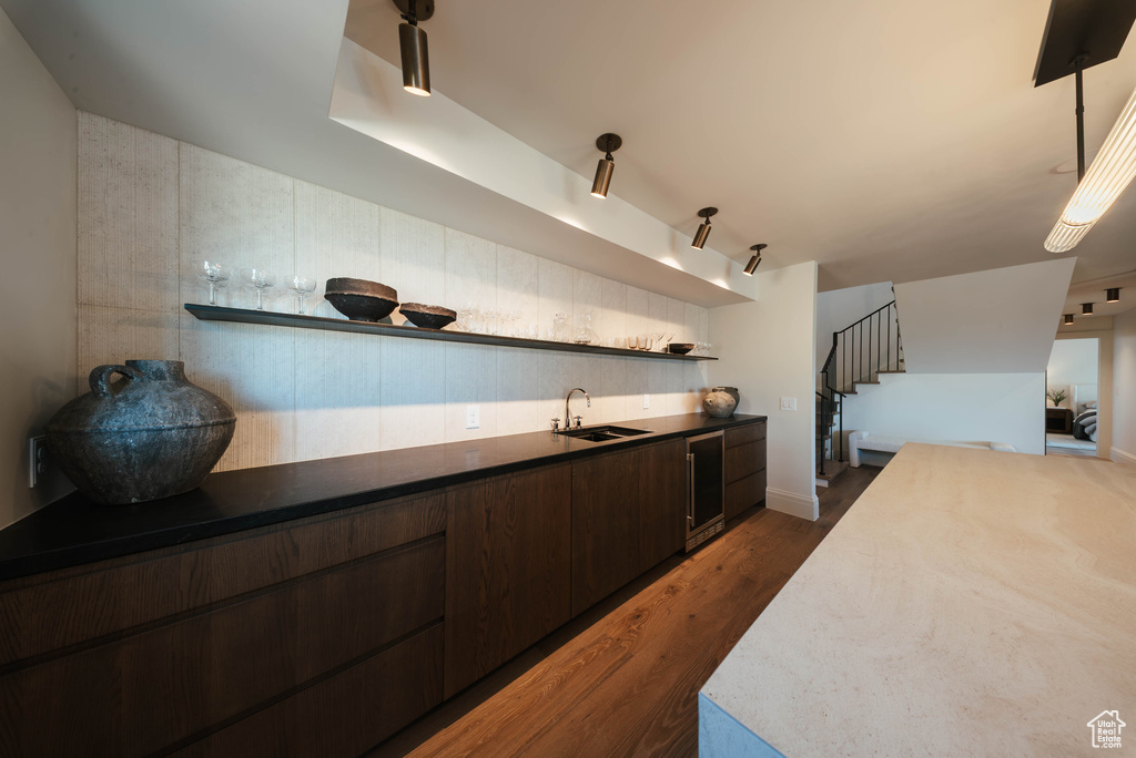 Kitchen with open shelves, dark brown cabinets, wine cooler, and dark wood-type flooring