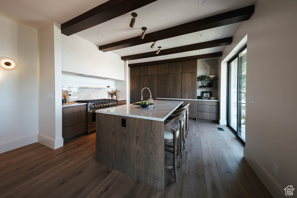 Kitchen with stainless steel range, modern cabinets, open shelves, beam ceiling, and dark wood-style floors