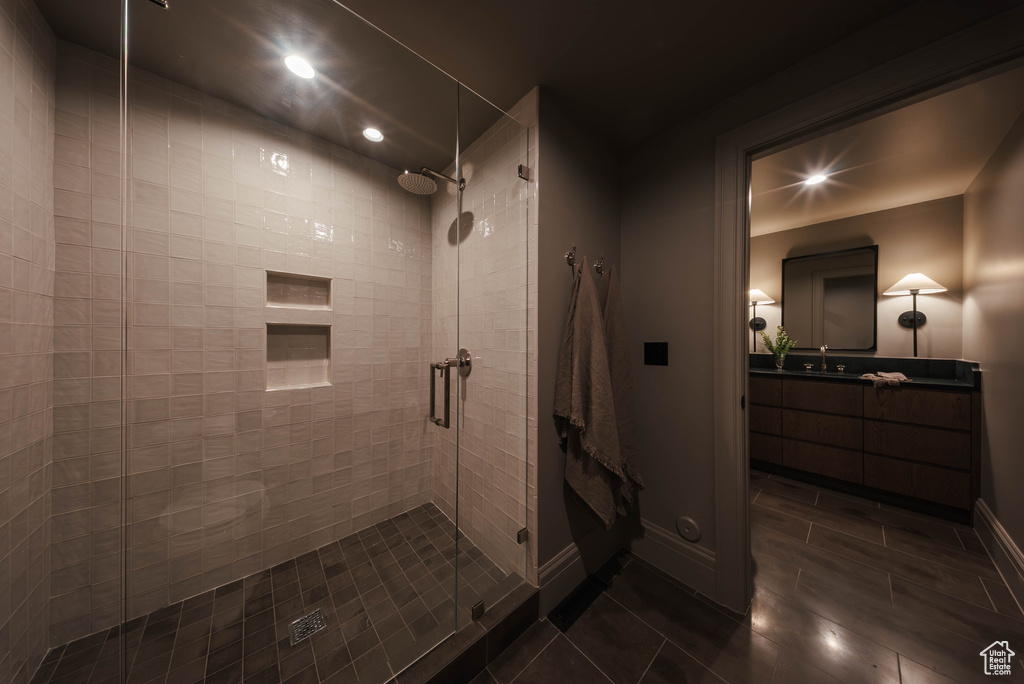 Bathroom with a stall shower, tile patterned flooring, recessed lighting, and vanity