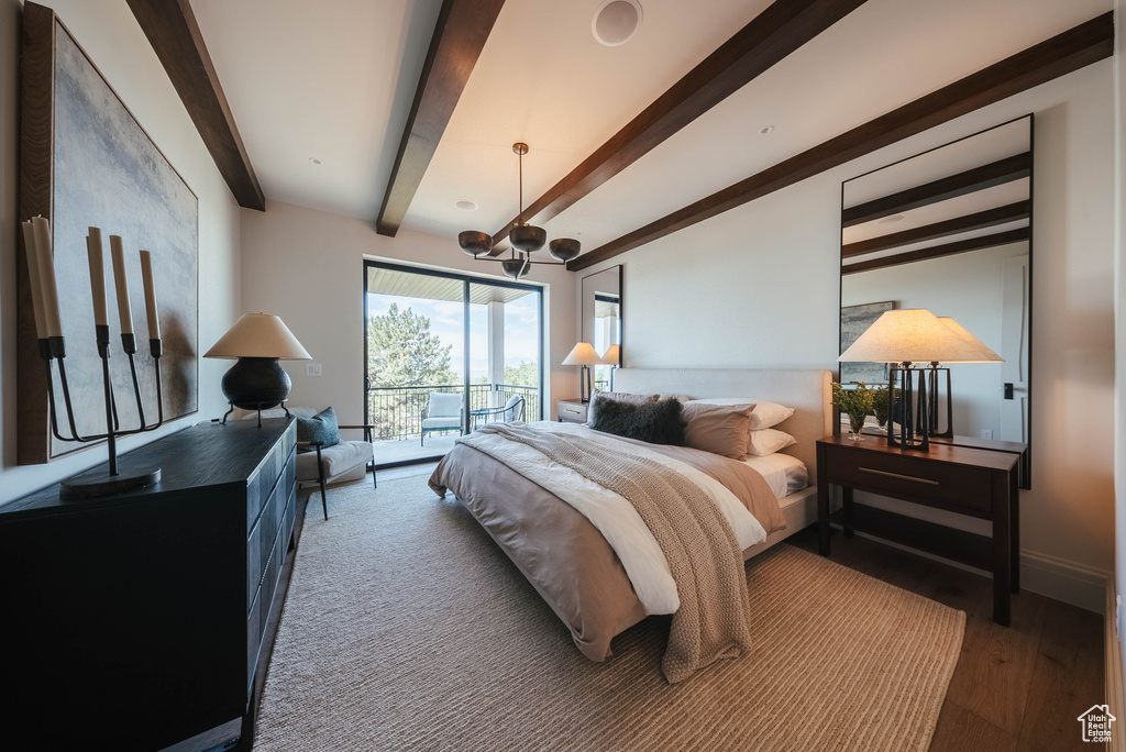 Bedroom with access to exterior, beamed ceiling, wood finished floors, and a chandelier