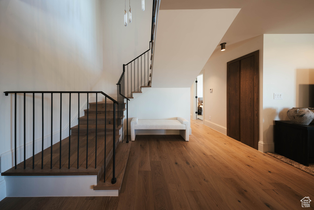 Stairway with wood finished floors and baseboards