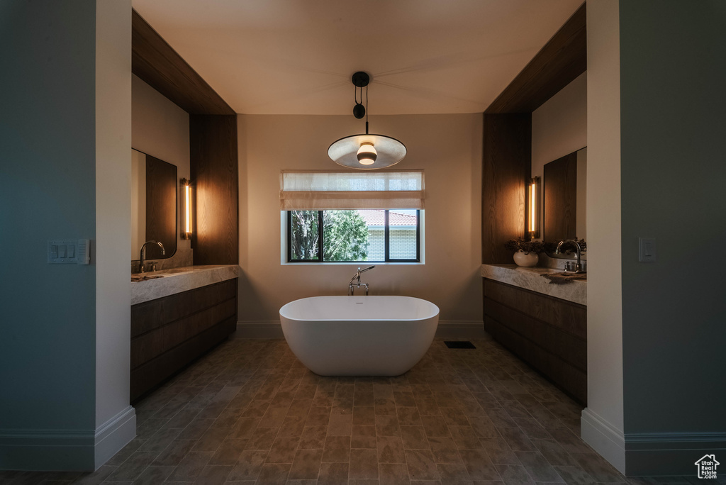 Full bathroom featuring a soaking tub and vanity