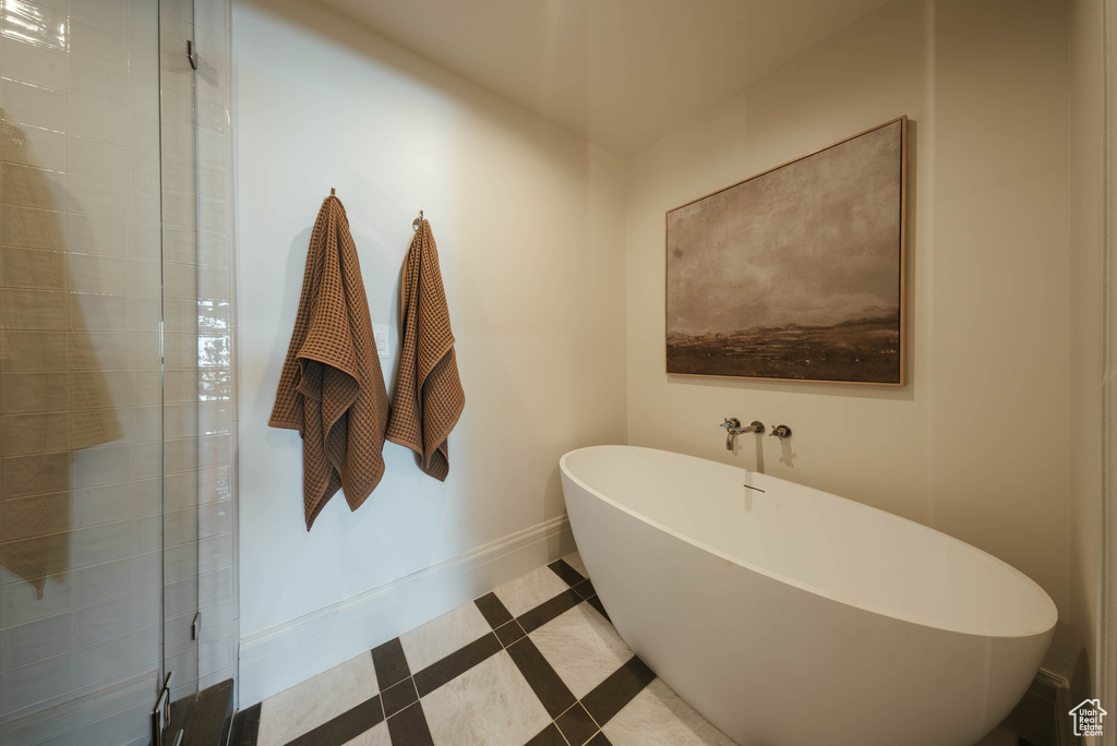 Full bathroom featuring a soaking tub, tile patterned flooring, tiled shower, and inlaid floor details