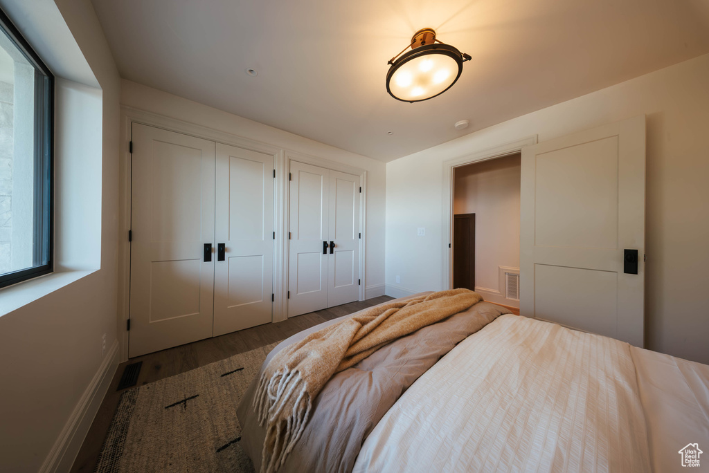 Bedroom with multiple closets and wood finished floors