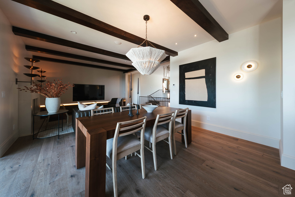 Dining room with beam ceiling, a chandelier, and wood finished floors