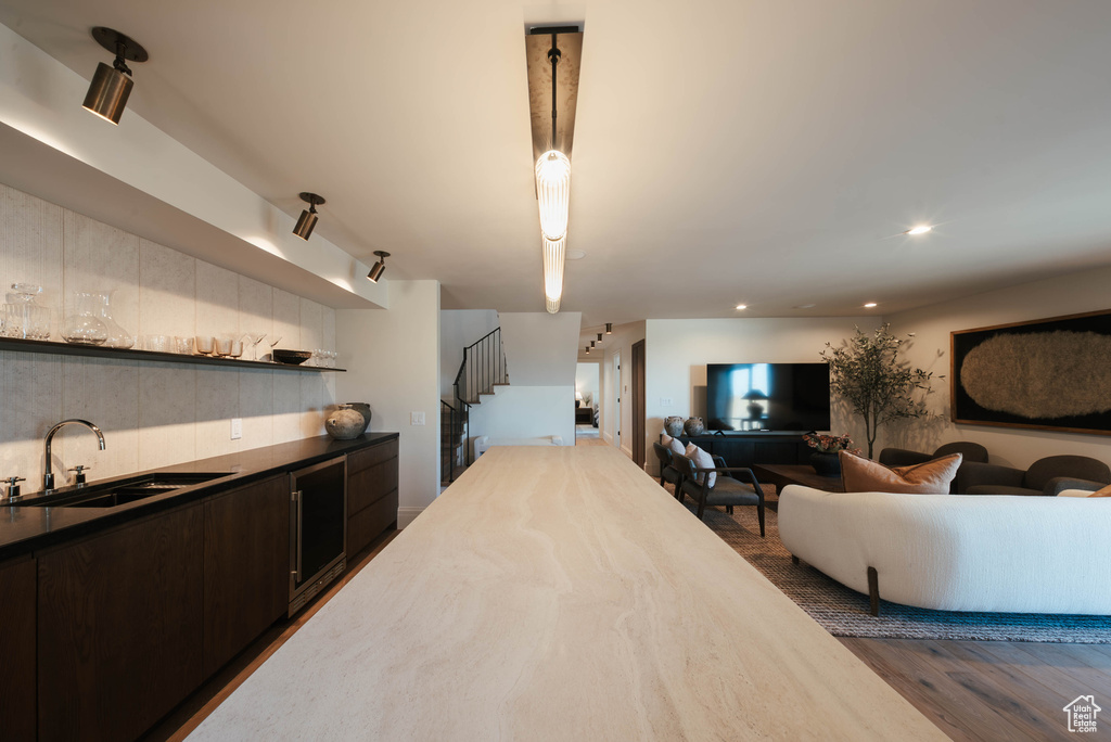 Kitchen with open floor plan, dark brown cabinetry, dark wood-style floors, open shelves, and recessed lighting