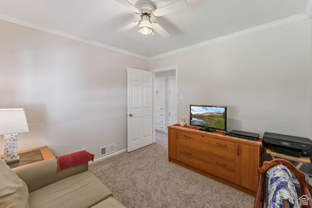 Living area with light carpet, crown molding, and a ceiling fan