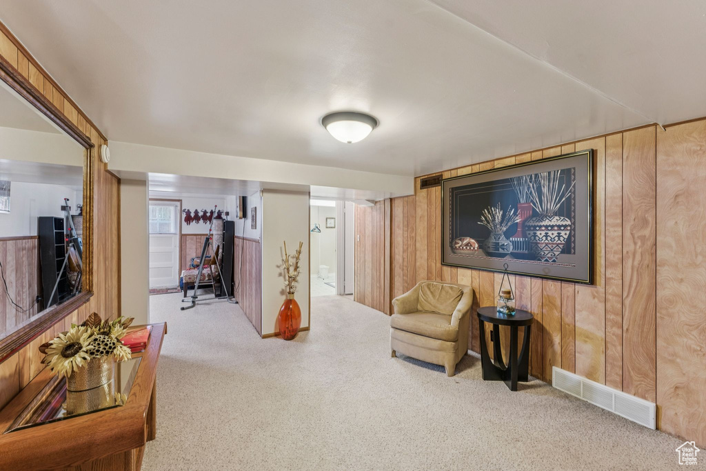 Living area featuring carpet floors and wood walls