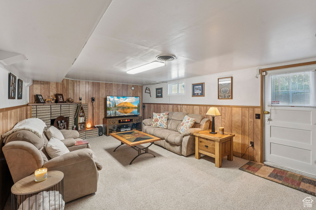 Carpeted living area featuring wooden walls, a wainscoted wall, and a fireplace