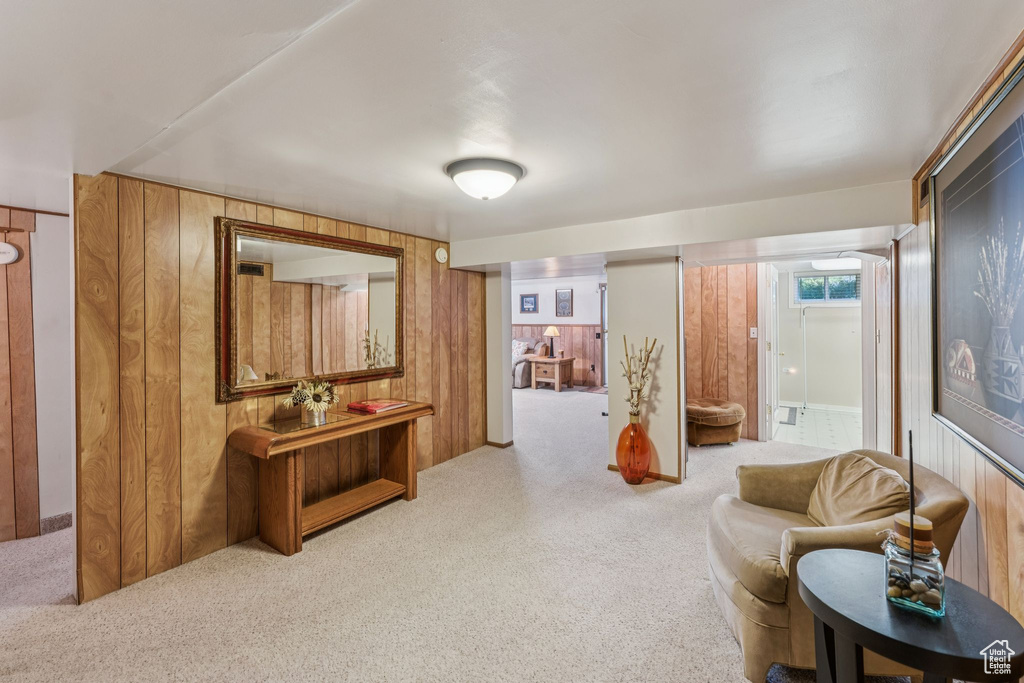 Carpeted living area featuring wooden walls