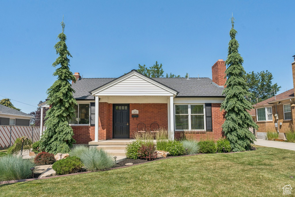 Bungalow-style home featuring brick siding, a chimney, and a shingled roof