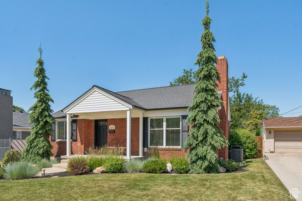 View of front of house featuring brick siding and a chimney