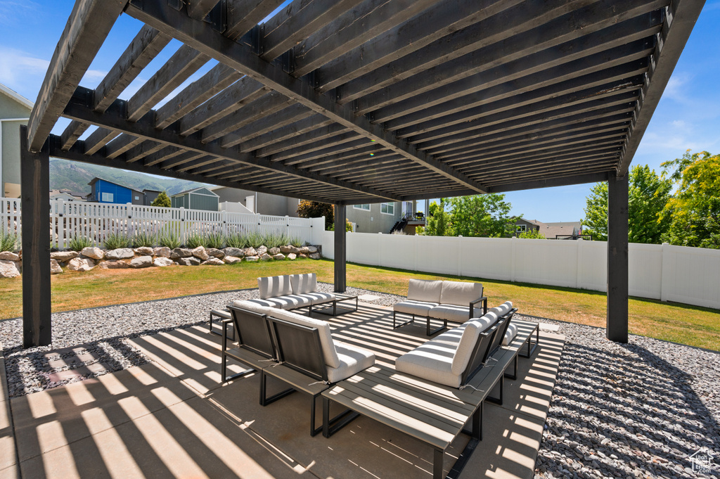 Fenced backyard with an outdoor hangout area, a patio, and a pergola
