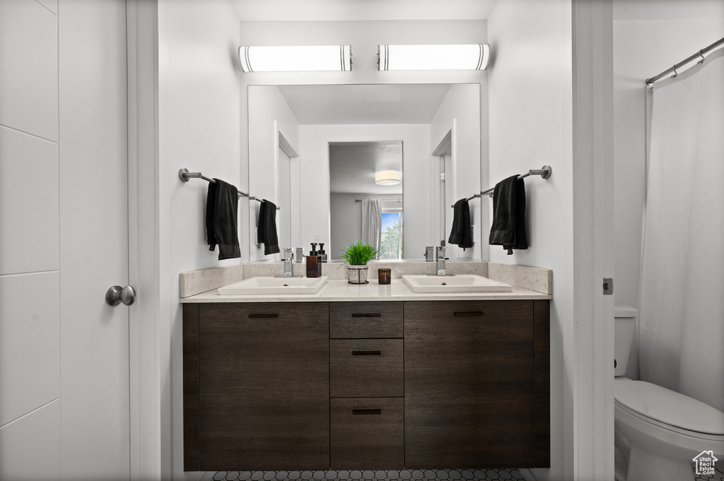 Bathroom featuring double vanity and toilet