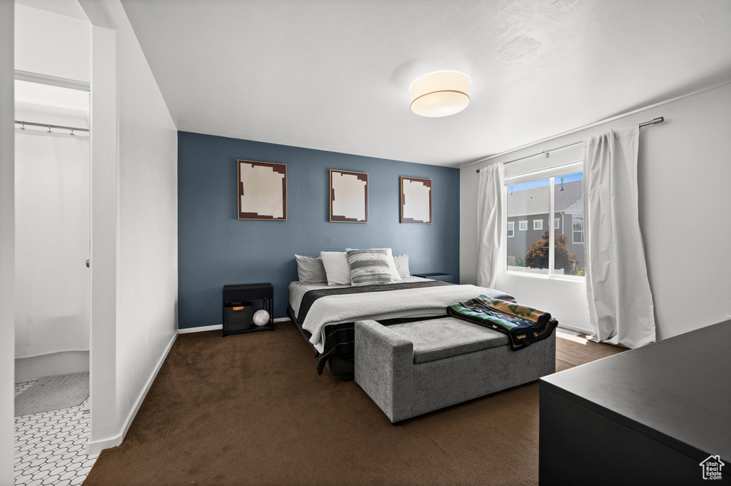 Bedroom with dark colored carpet and baseboards