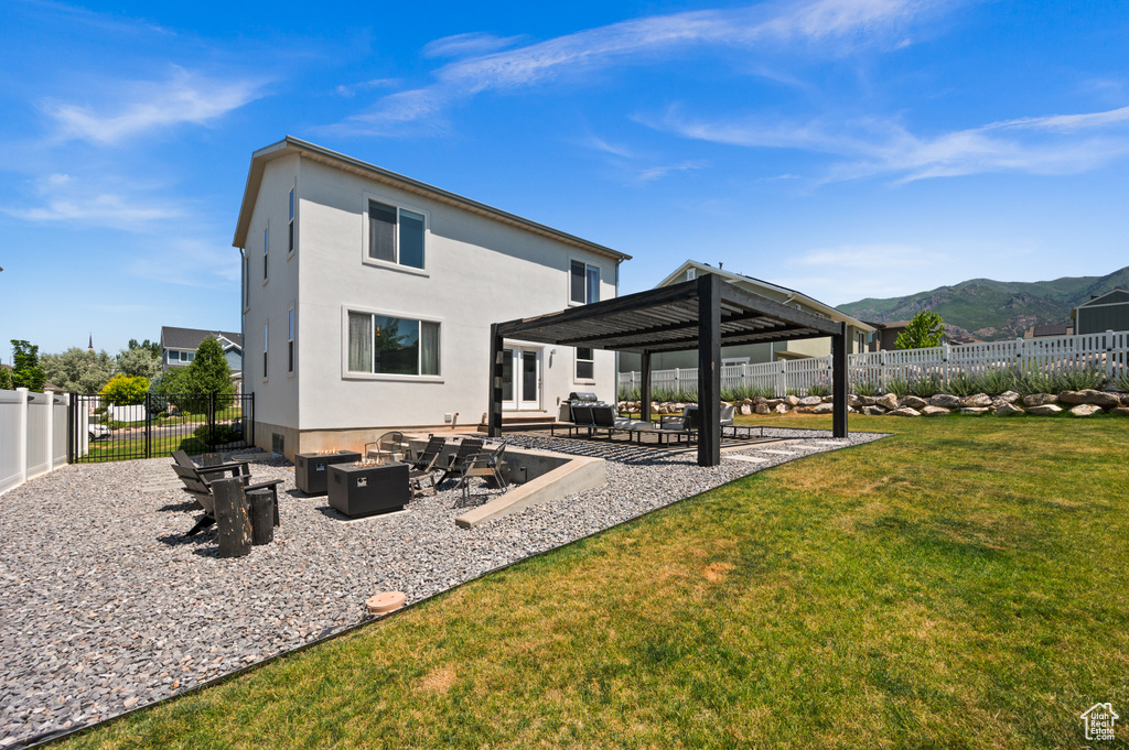 Back of property featuring an outdoor fire pit, a patio area, a gazebo, a mountain view, and a fenced backyard