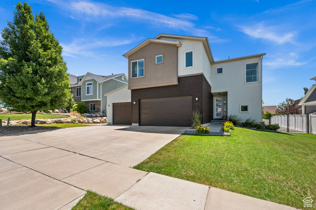 View of front of home featuring concrete driveway, an attached garage, and stucco siding