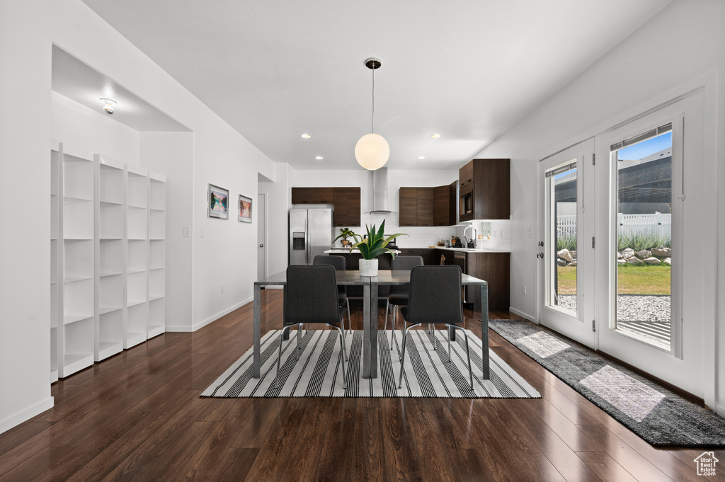 Dining space with dark wood-type flooring and recessed lighting