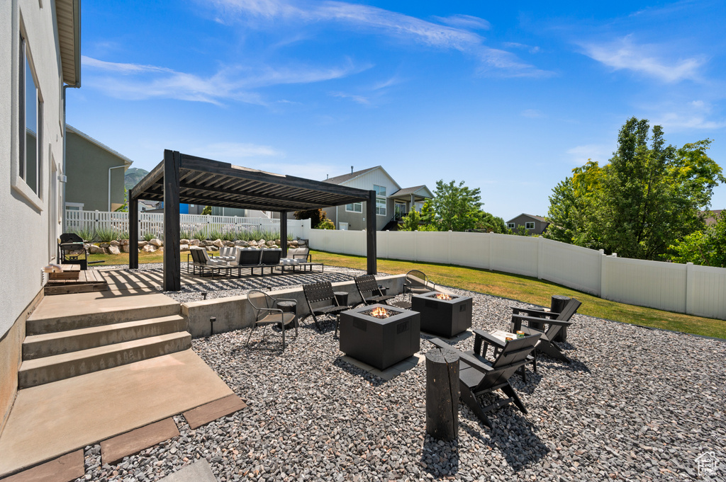 Fenced backyard featuring an outdoor living space with a fire pit, a patio, and a pergola