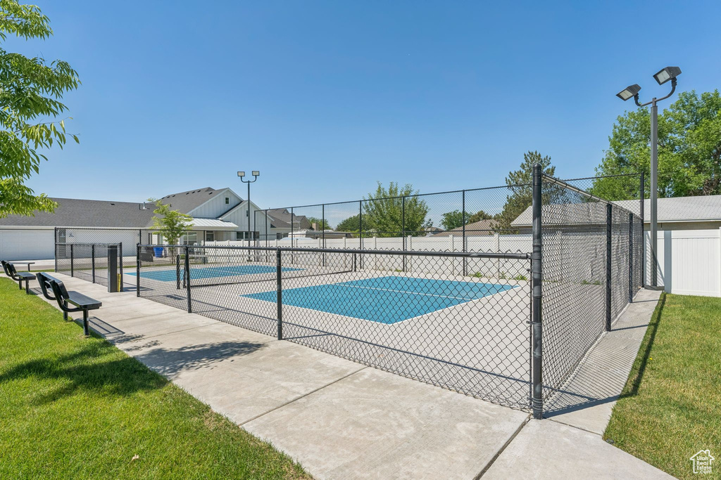 View of swimming pool featuring a tennis court and a residential view