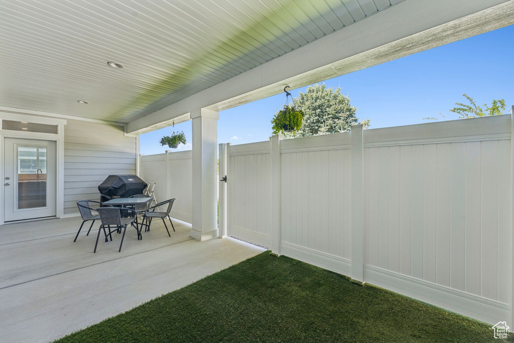 View of patio with a grill