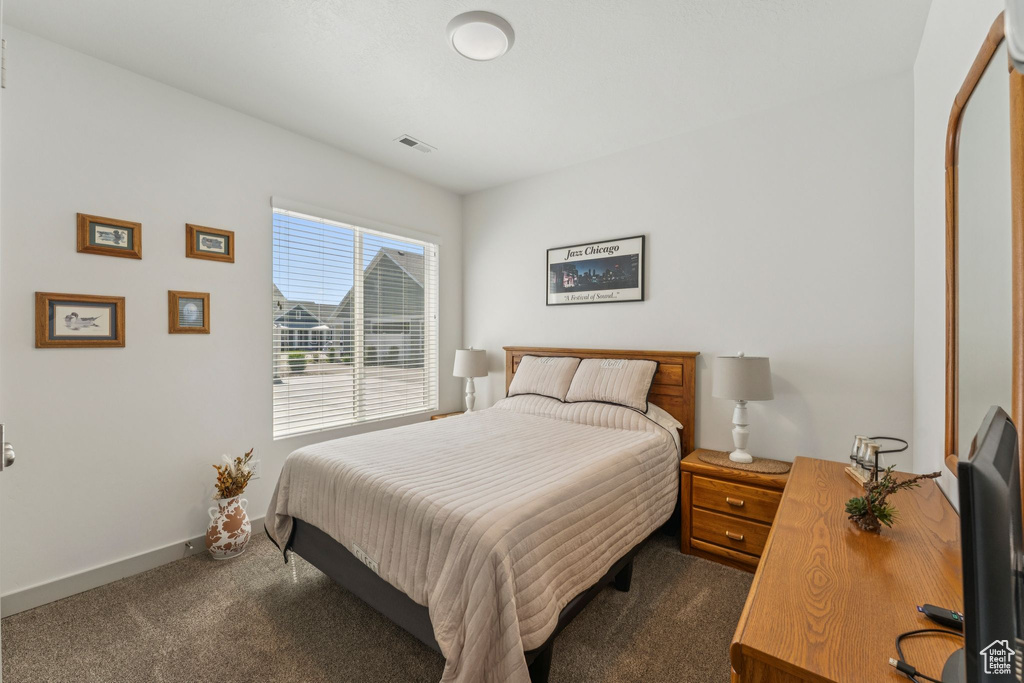 Bedroom with dark carpet and baseboards