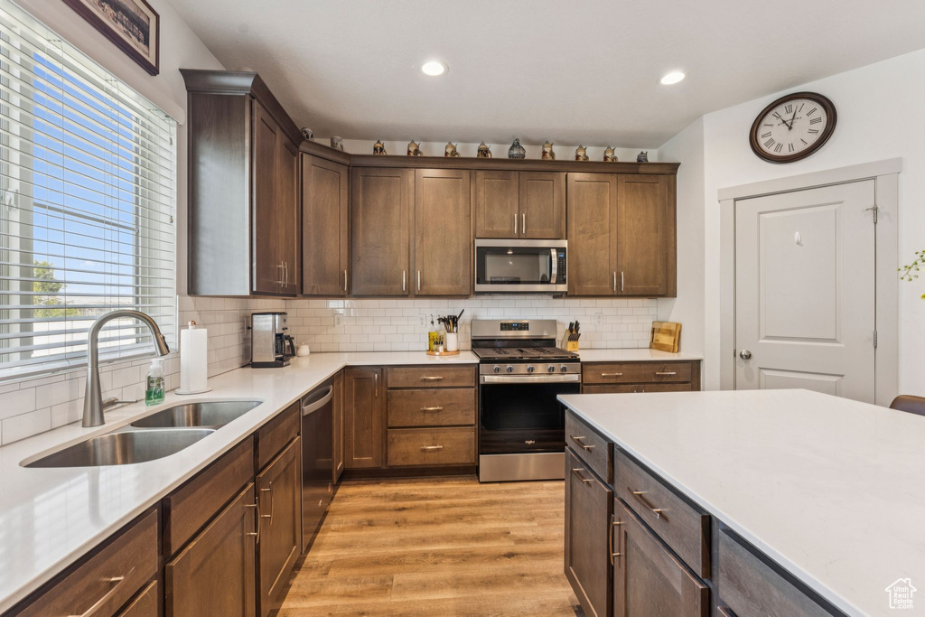 Kitchen featuring stainless steel appliances, light wood-style flooring, plenty of natural light, light countertops, and recessed lighting