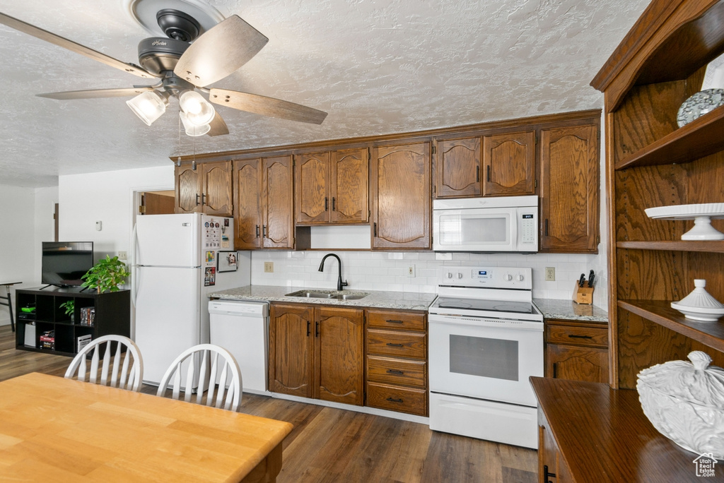 Kitchen featuring white appliances, open shelves, dark wood-style floors, a ceiling fan, and tasteful backsplash