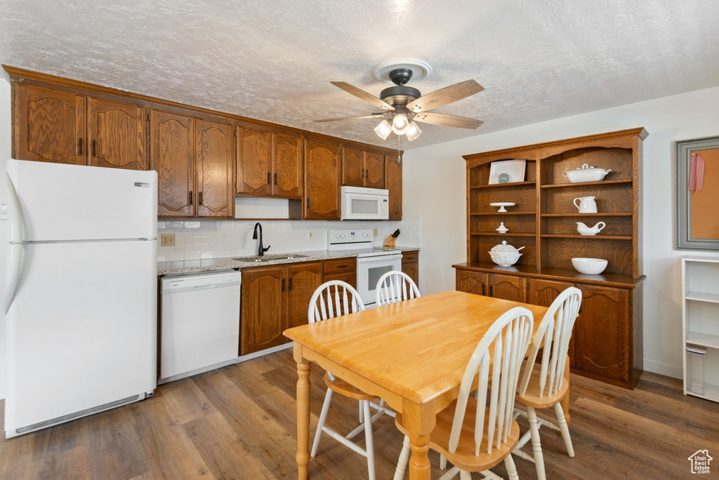 Kitchen featuring white appliances, a ceiling fan, wood finished floors, open shelves, and tasteful backsplash