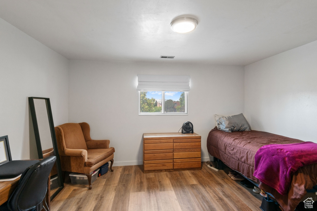 Bedroom with wood finished floors and baseboards