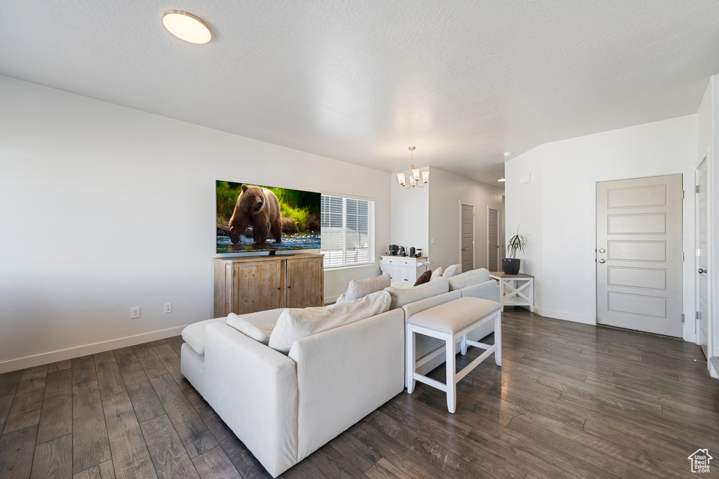 Living area featuring a chandelier and dark wood-type flooring