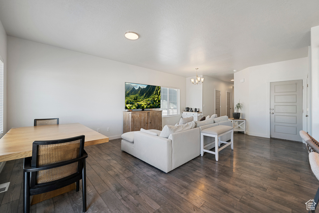 Living area featuring a chandelier and dark wood-type flooring