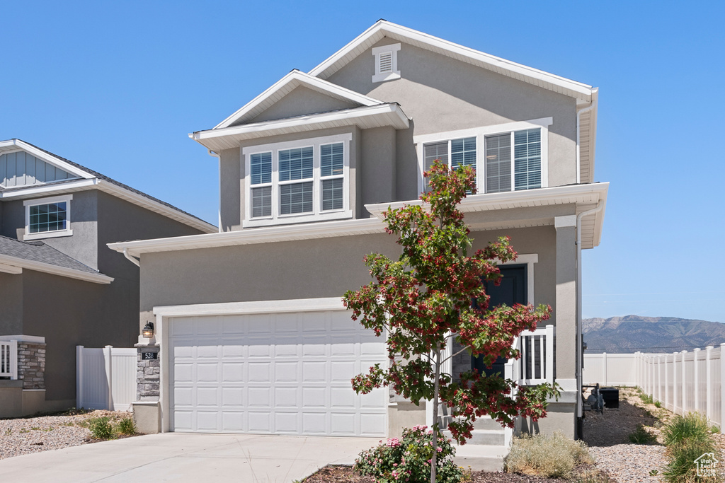 Traditional home with concrete driveway, stucco siding, and an attached garage