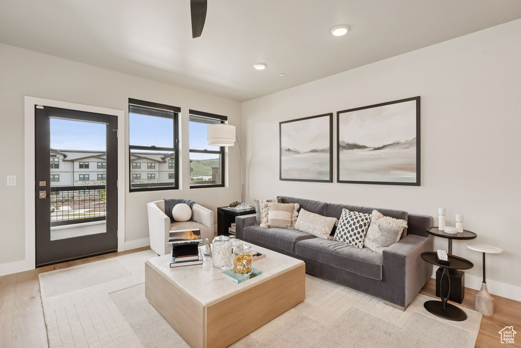 Living room featuring light wood finished floors, a ceiling fan, and recessed lighting