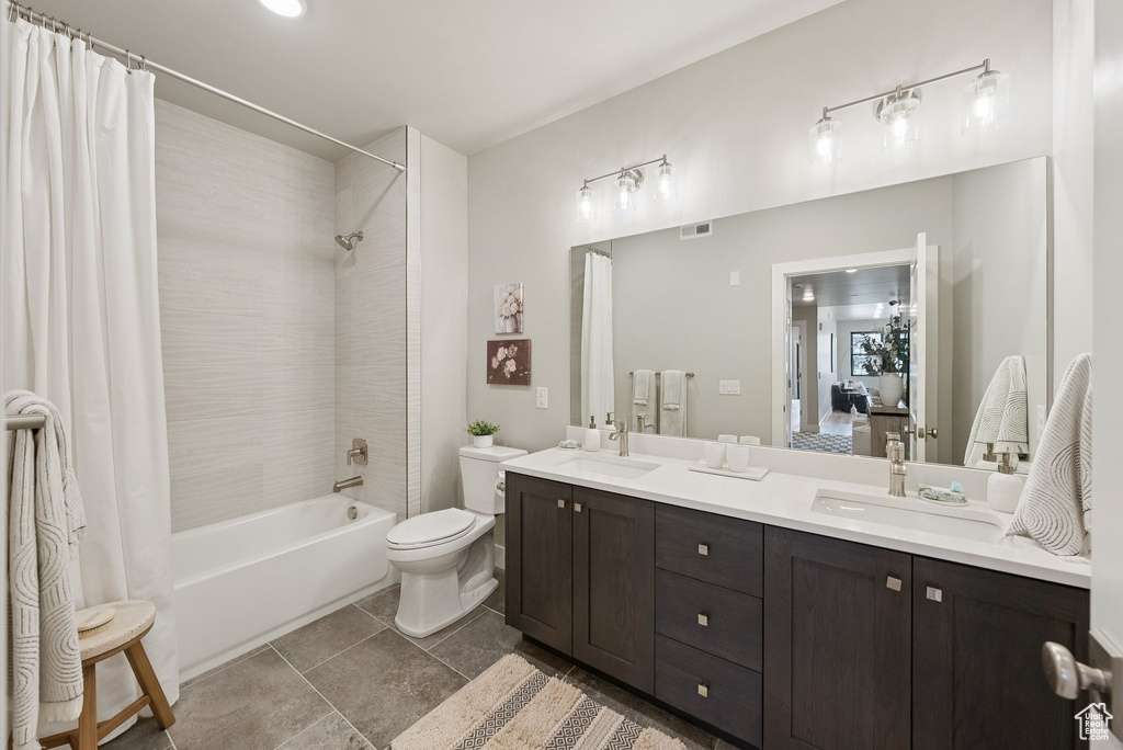 Full bathroom featuring shower / tub combo and double vanity