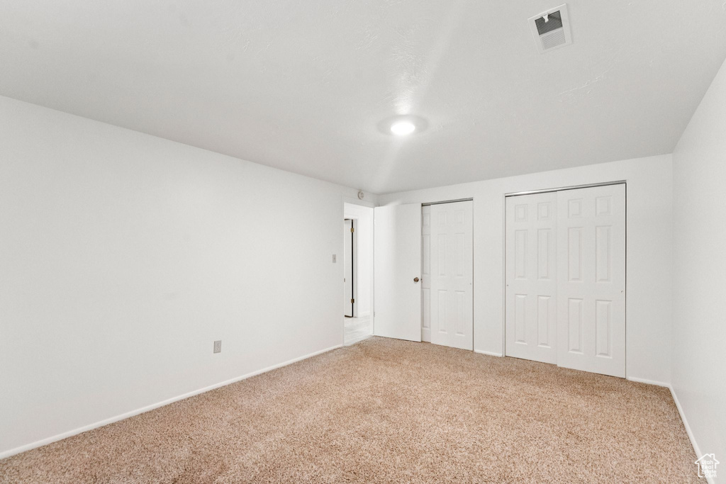 Unfurnished bedroom with multiple closets and carpet floors