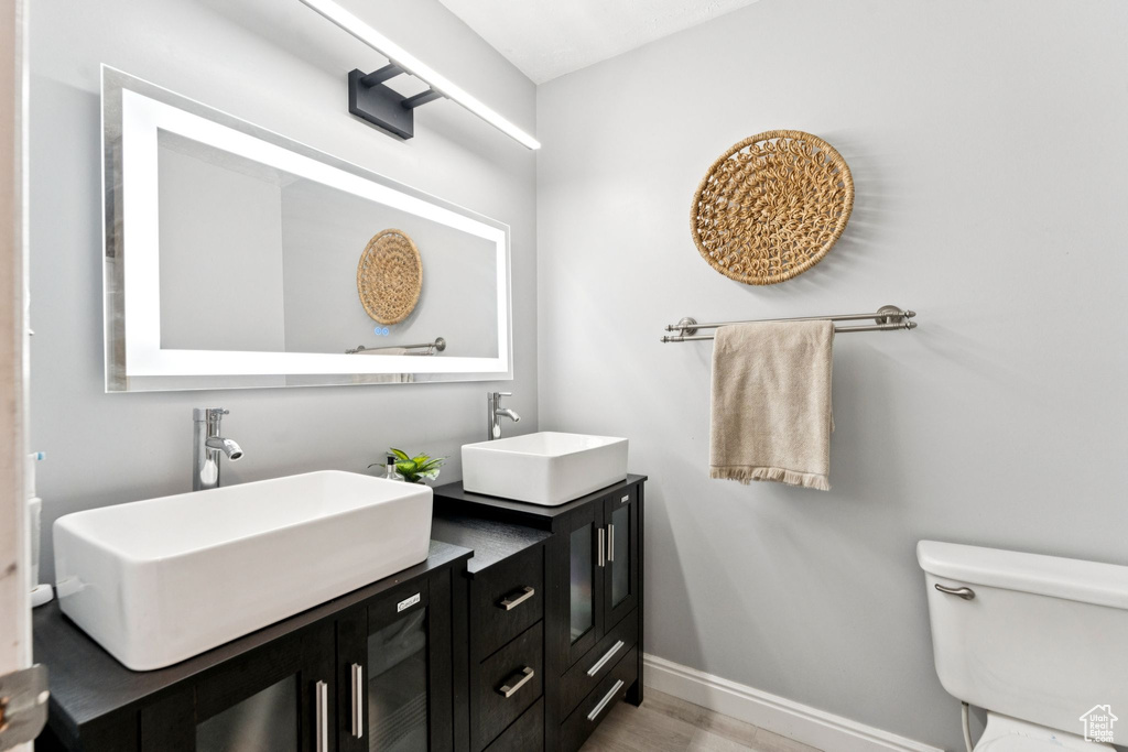 Bathroom featuring double vanity and wood finished floors