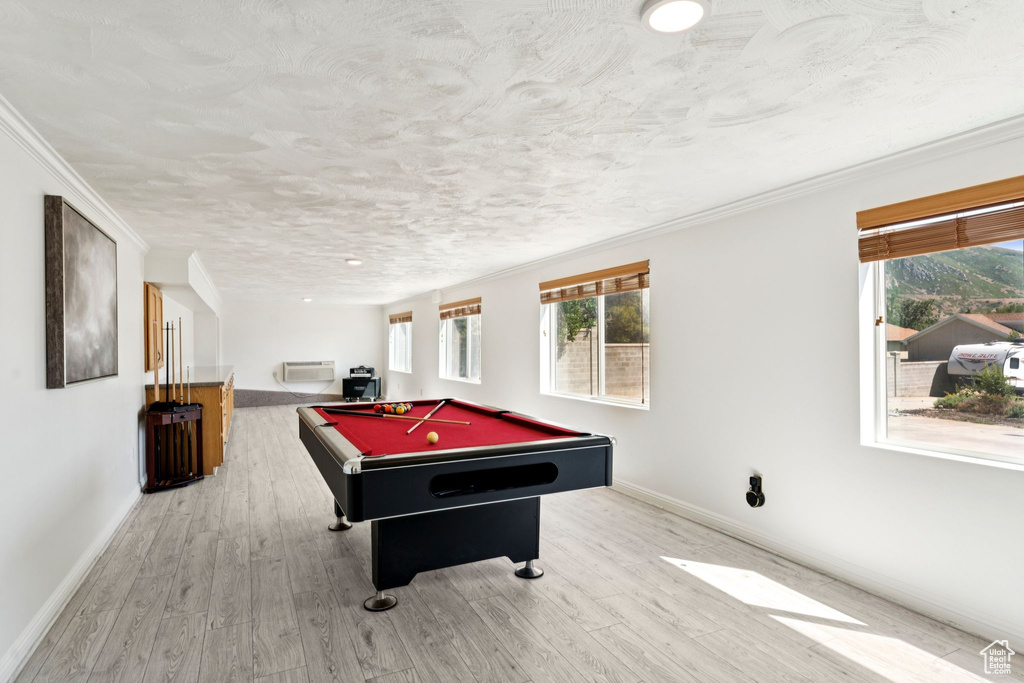 Playroom with billiards table, wood finished floors, a wall mounted AC, ornamental molding, and a textured ceiling