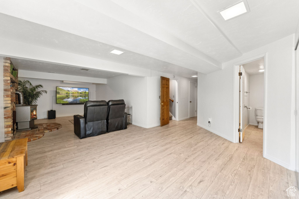 Unfurnished living room featuring a wood stove and light wood-type flooring
