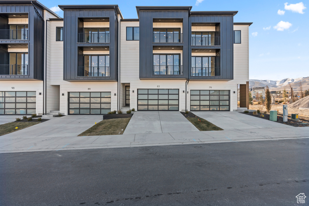 View of front of property featuring a garage, driveway, and a mountain view