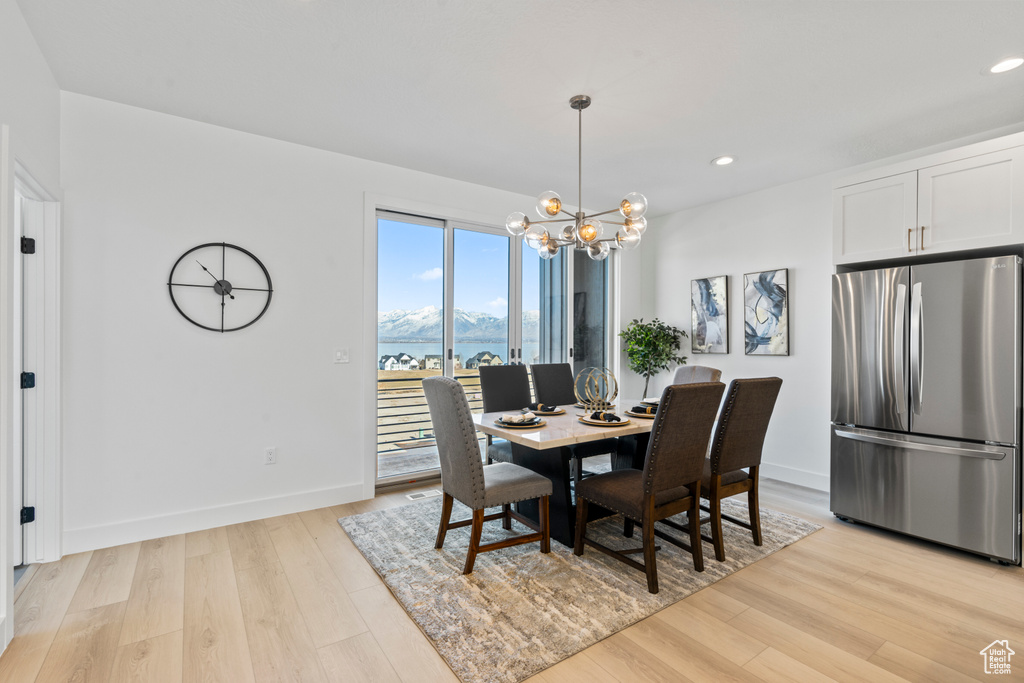 Dining space with light wood-style floors, a chandelier, recessed lighting, and a mountain view