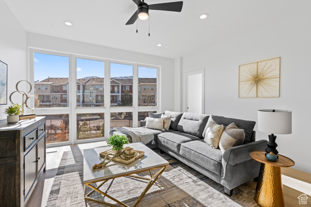 Living area with ceiling fan, wood finished floors, and recessed lighting