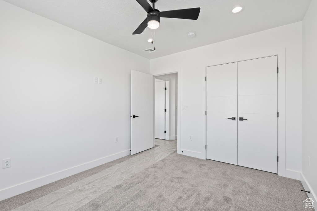 Unfurnished bedroom with carpet, a closet, a ceiling fan, and recessed lighting