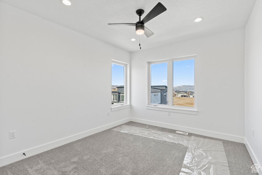 Spare room featuring carpet floors, a ceiling fan, and recessed lighting