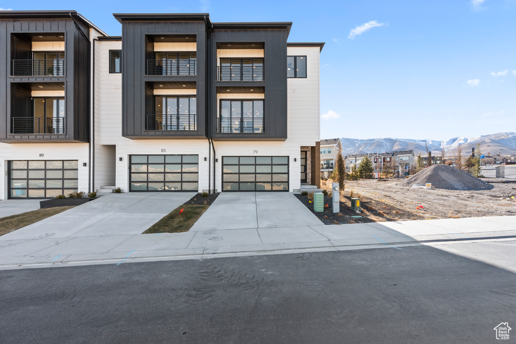 Modern home with a mountain view, a garage, and driveway