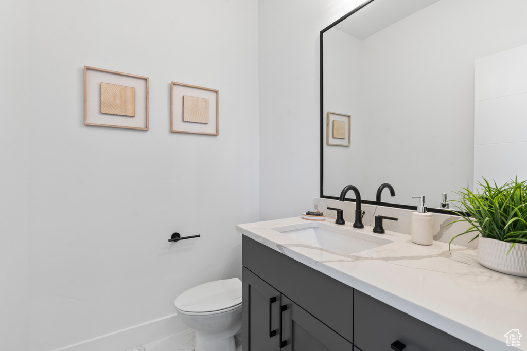 Half bathroom featuring vanity and marble look tile flooring