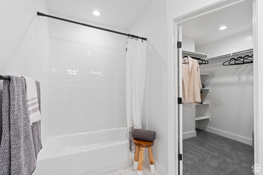 Full bath with shower / bath combo with shower curtain, a spacious closet, and recessed lighting