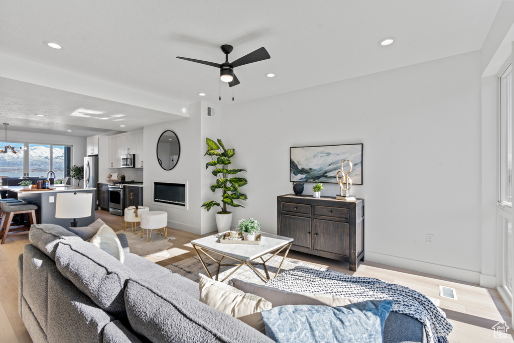Living room featuring a ceiling fan, light wood-type flooring, and recessed lighting
