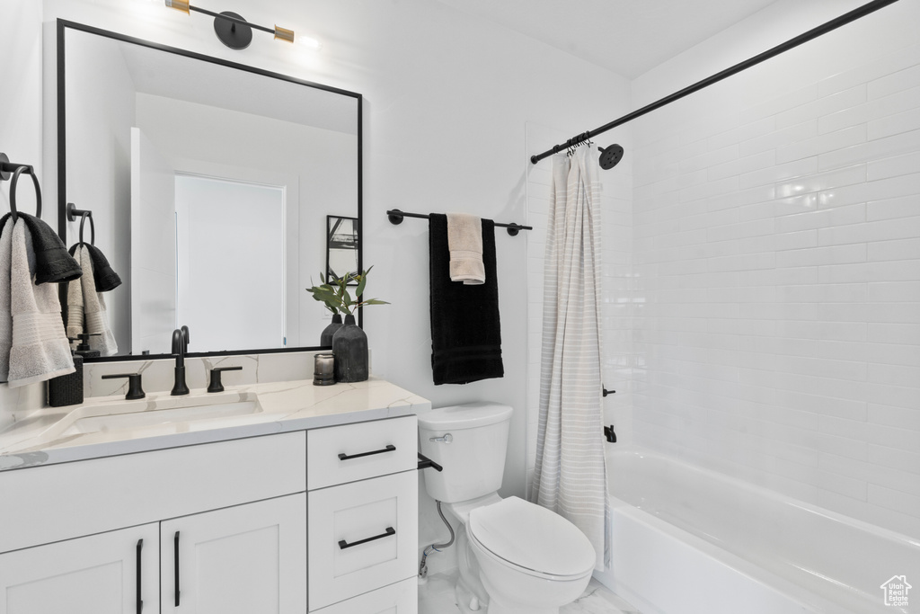 Bathroom featuring vanity, shower / bath combo, and marble finish floors