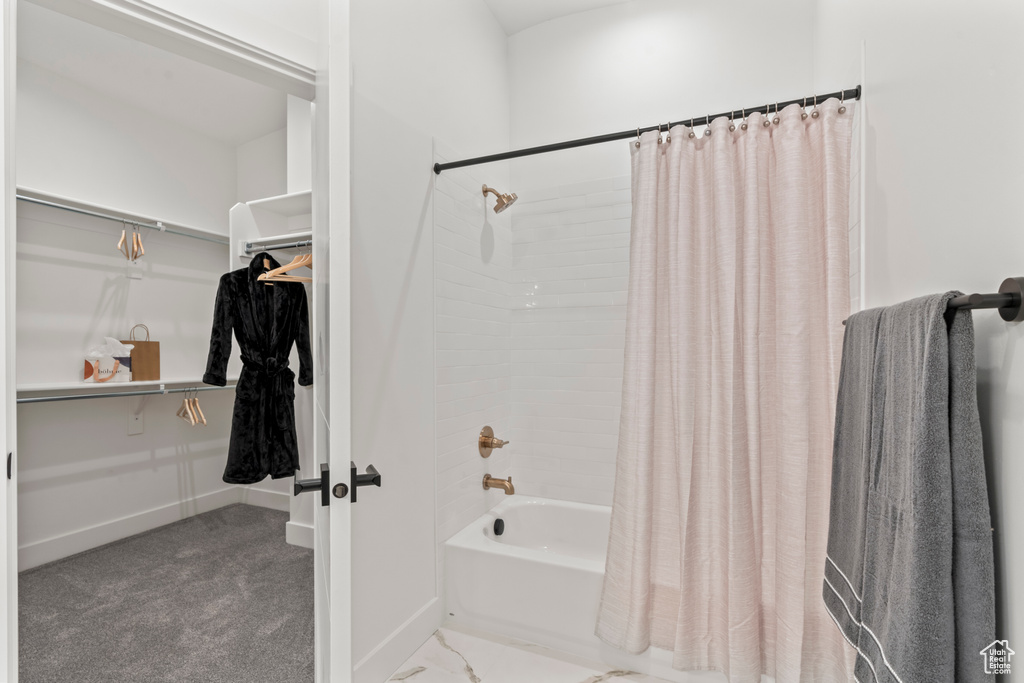 Bathroom with shower / bathtub combination with curtain and a spacious closet